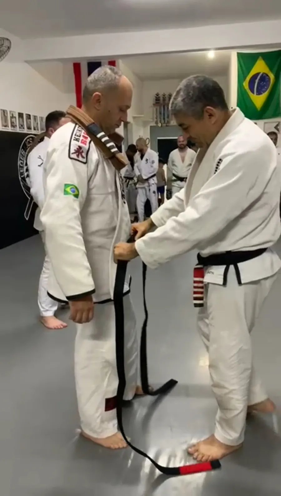 Faixa-preta com ponteira vermelha passando pela cintura